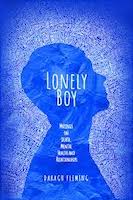 The cover of Daragh Fleming's book Lonely Boy is blue with a silhouette of a side profile of a person's face. The title of the book is printed within the head as if it's on the person's mind and there is a word cloud of white words surrounding the head. Some of these words are positive, some are negative and they reflect all of the things that are on the author's mind