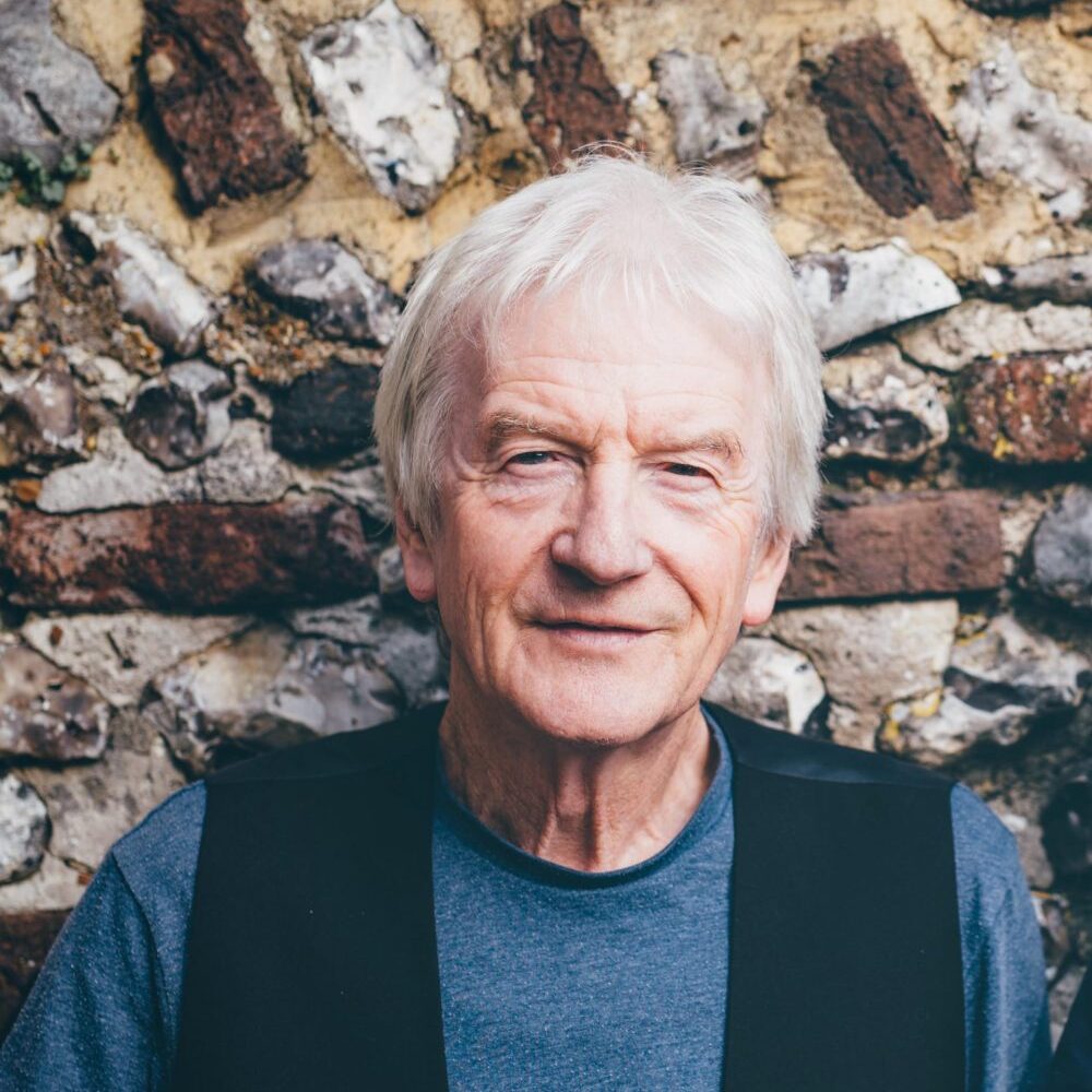 a man in front of an old brick wall