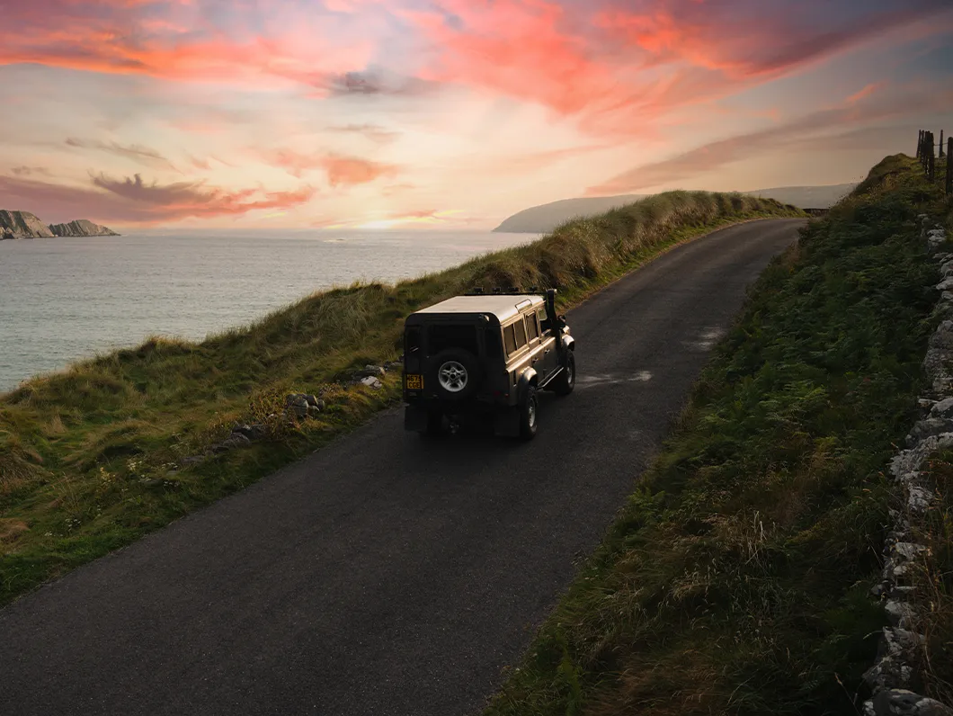 Car overlooking Lackenakea Bay Beach in County Cork at sunset.