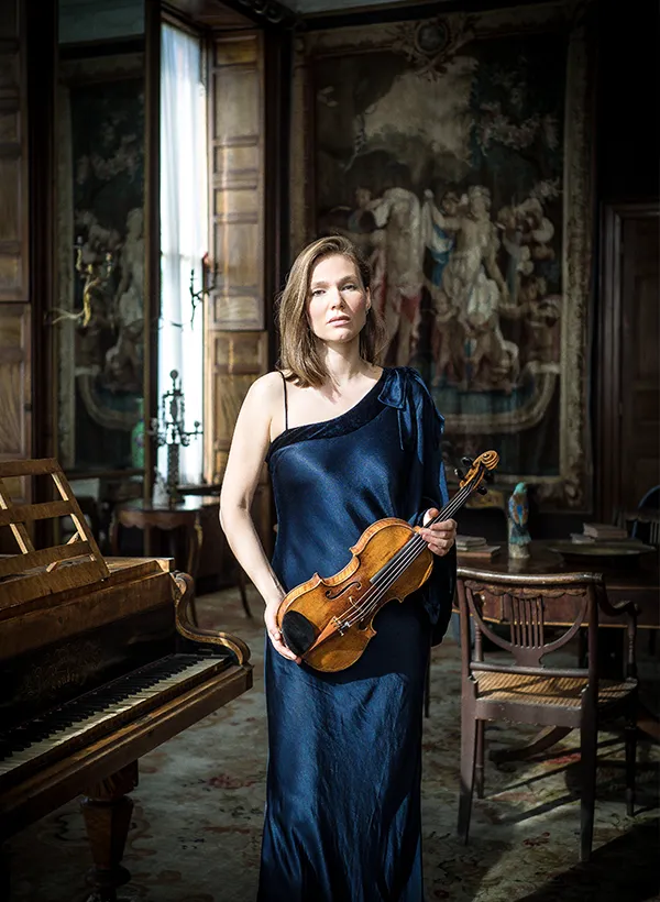 Woman holding violin indoors