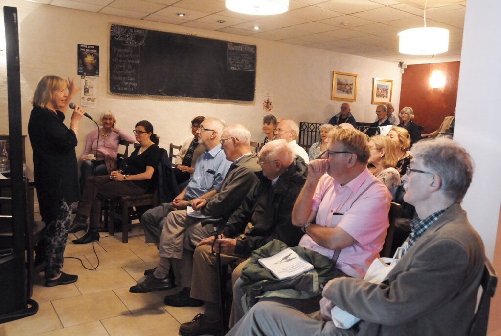Evelyn Grant introduces one of her Morning Talks in the Brick Oven Restaurant