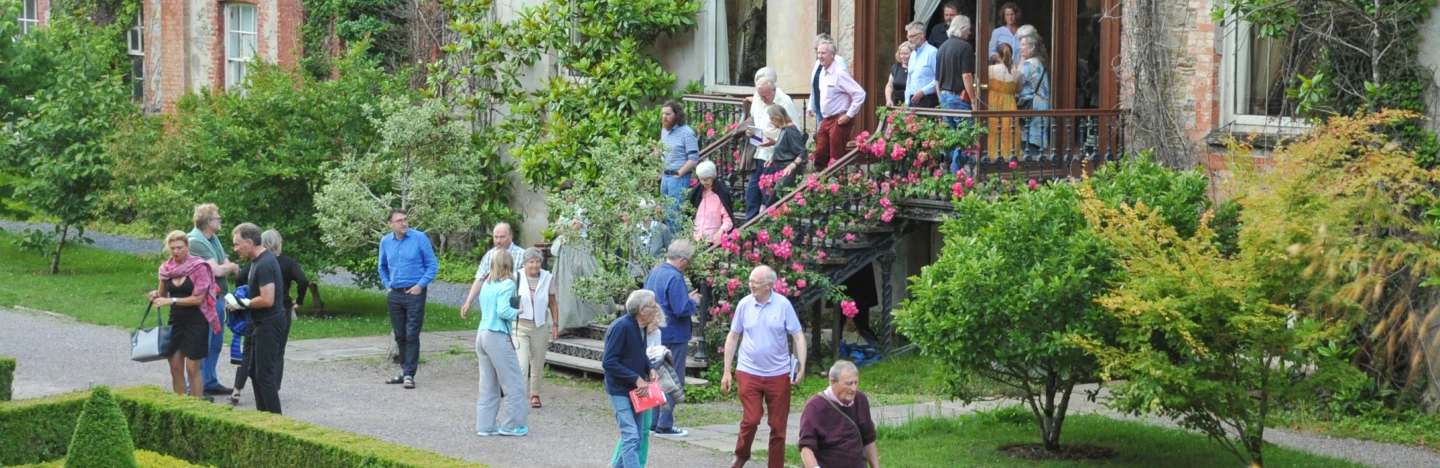 people leaving building and standing in garden